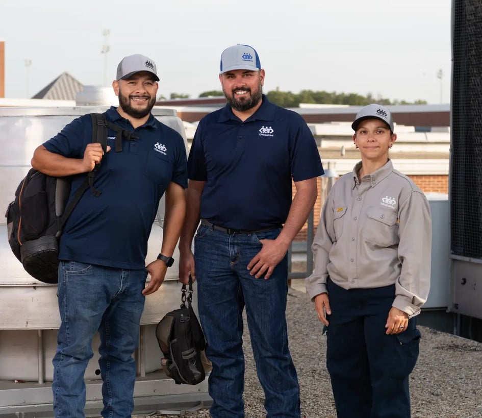 Commercial HVAC service and maintenance professionals pose on roof of a Texas high school