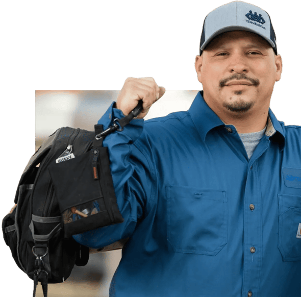 Experienced HVAC manager in TDIndustries ball cap lifts a tool bag